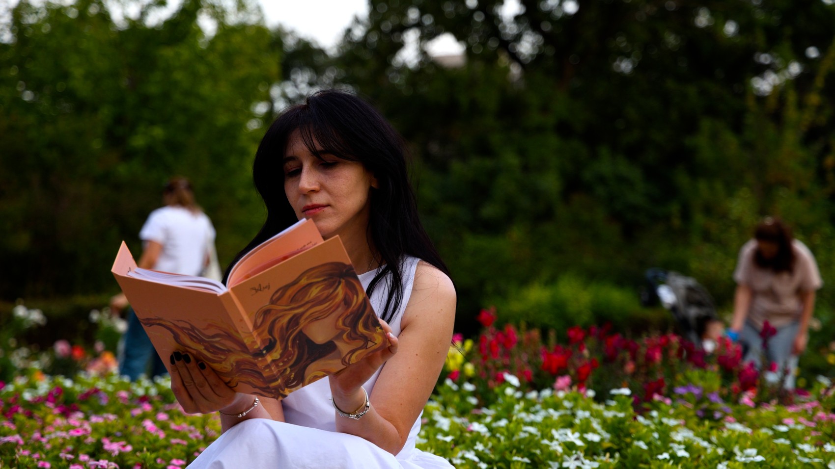 Una lectora con la agenda Fuego en un jardín
